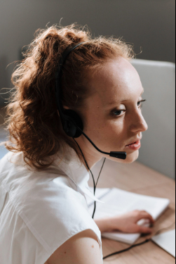 Téléconseiller en relation client à distance travaillant sur ordinateur et communiquant avec un client au téléphone.